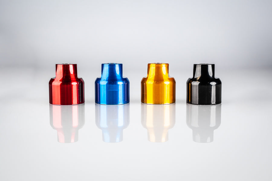 Four Santoro Fabworx Cadillac crash bar wheel mounts in red, blue, gold and black on a reflective surface