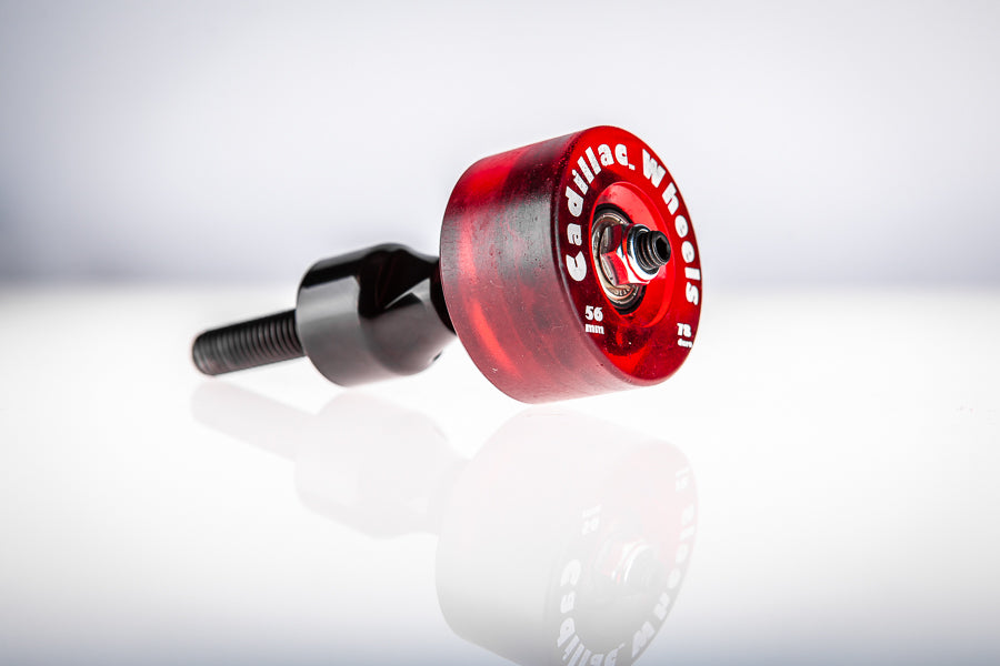 Red Santoro Fabworx Cadillac crash bar wheel with black mount and bolt, close side view on a reflective surface