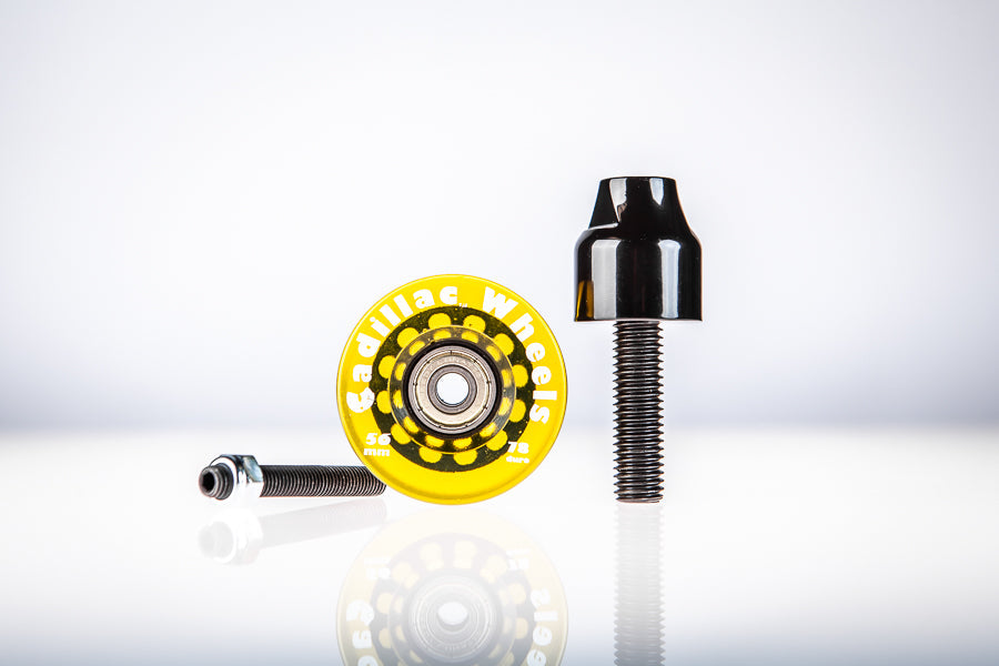 Yellow Santoro Fabworx Cadillac crash bar wheel with black mount and bolt on a reflective surface