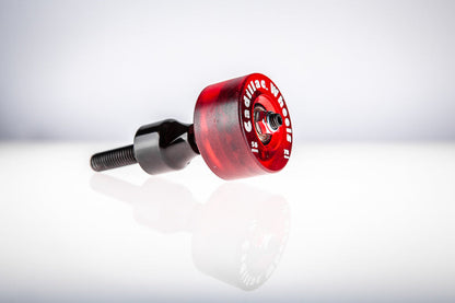 Red Santoro Fabworx Cadillac crash bar wheel with black mount and bolt, side view on a reflective surface